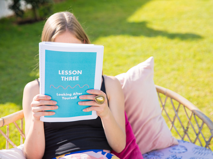 This is an image of a lady in her backyard reading through how to support yourself during divorce information.